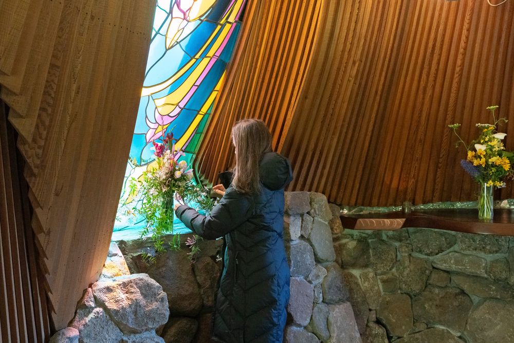 A couple embraces in a rustic outdoor setting with stone walls and natural lighting.
