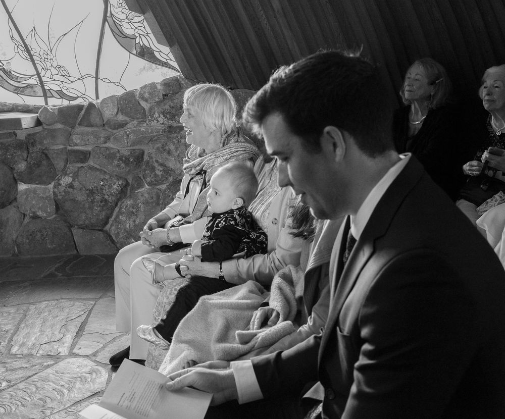 Black and white photo series showing people signing documents at a desk during a ceremony.