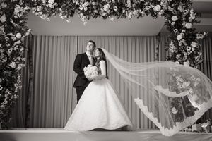 A series of black and white wedding photos showing dancing and celebration in an elegant venue with floral decorations.