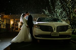 Nighttime wedding portraits with luxury car and string lights creating magical ambiance.