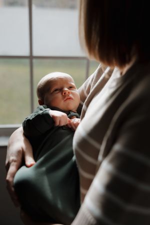 A series of photos showing a baby resting on someone's shoulder near a window.