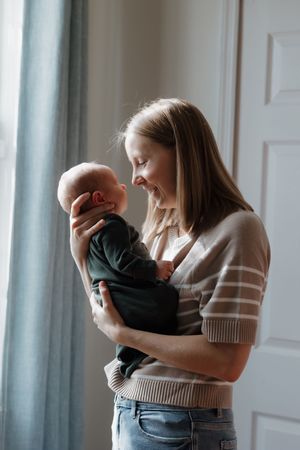 A series of tender moments between parent and baby near a window with white curtains.