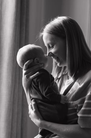 Black and white series of intimate parent-child moments by a window.