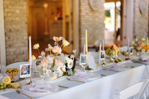 Elegant wedding reception tables decorated with floral centerpieces and candlelight in a rustic brick venue.