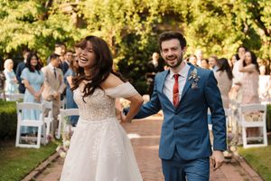 Wedding guests celebrating and dancing joyfully at an outdoor garden reception.