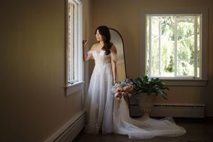 Elegant bridal portrait in a sunlit room with white curtains and vintage interior details.