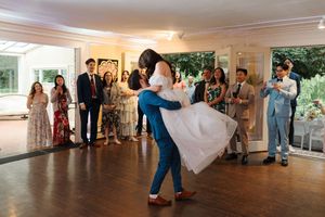 Wedding guests dance and celebrate on a spacious wooden dance floor during a reception.