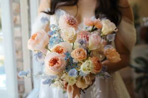Elegant peach and cream garden roses arranged in a delicate bouquet with soft natural lighting.