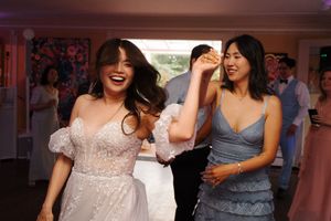 Wedding reception dance party with guests enjoying themselves under warm lighting.