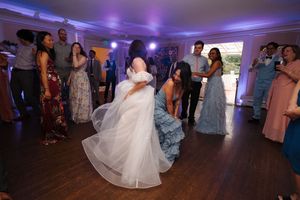 Wedding reception dance floor illuminated with purple lighting as guests dance and celebrate.