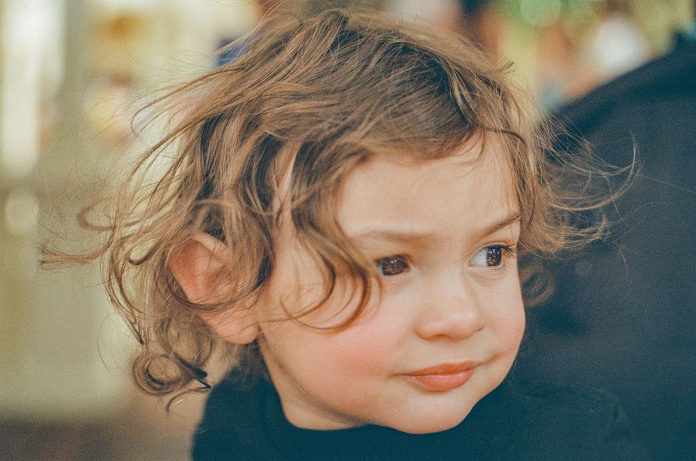 Close-up portrait with curly hair and natural lighting.