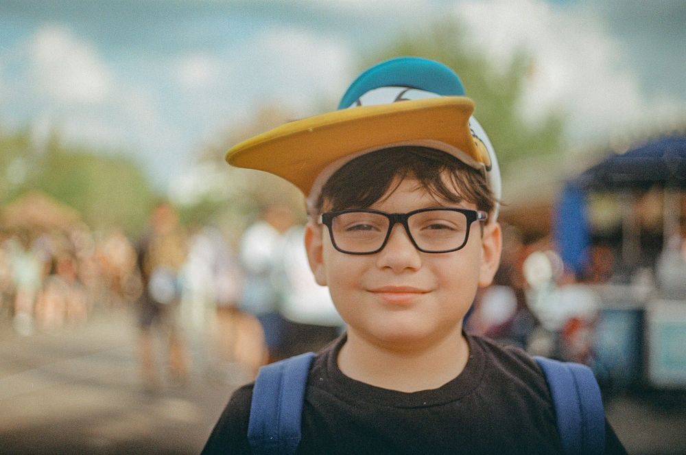 A sunny day portrait with a baseball cap and backpack outdoors.