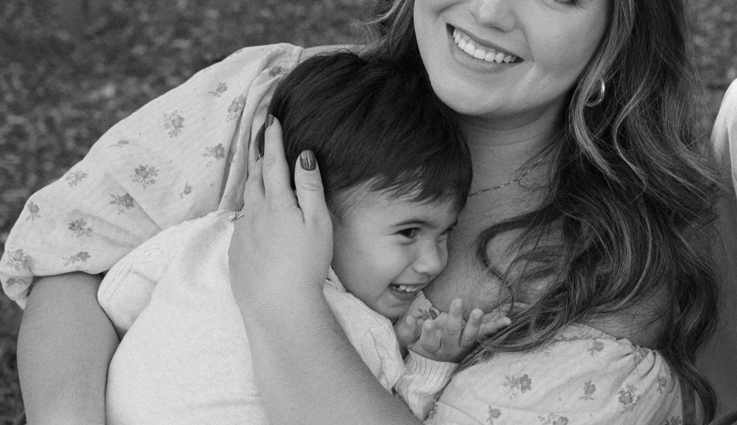 A black and white portrait capturing an intimate moment between mother and child.