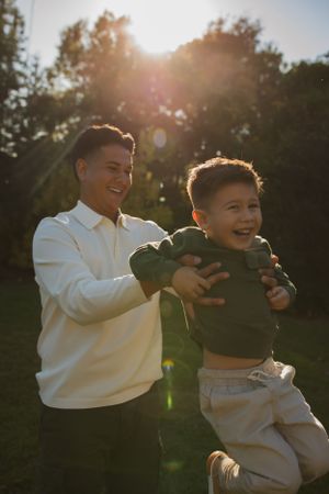 A joyful moment between parent and child playing outdoors during sunset.