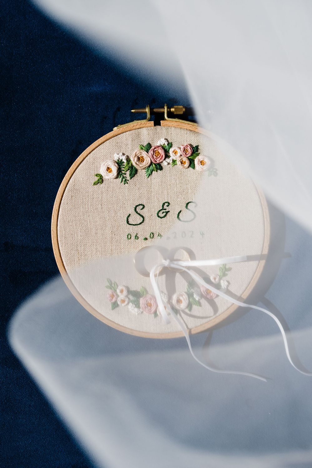 Embroidered wedding hoop art with floral details and initials S & E on natural linen.