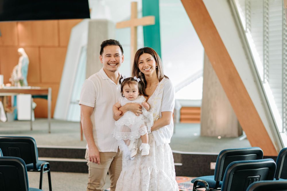 Family portrait in a modern church with geometric orange and teal wall decorations.