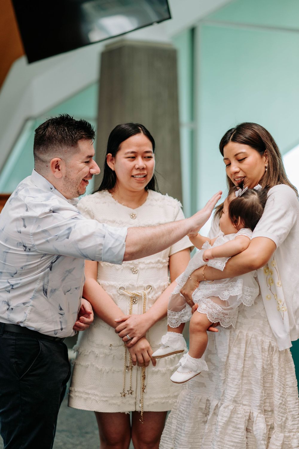 Group sharing joyful moment during church ceremony in white attire.