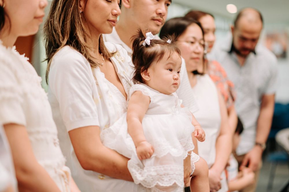 Group gathered for religious ceremony wearing coordinated white outfits.