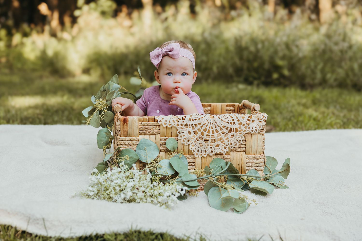 Outdoor portrait setup featuring a woven basket with lace trim and fresh eucalyptus. Colorado Springs Photographer.