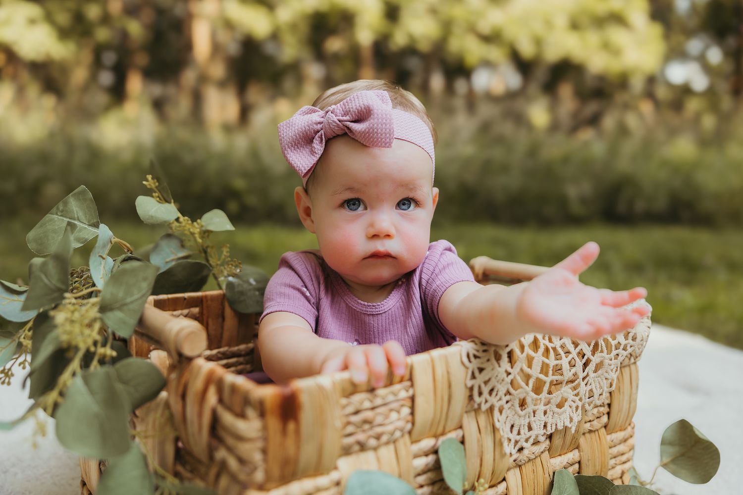 Rustic wicker basket decorated with lace and eucalyptus leaves in natural outdoor lighting. Colorado Springs Photographer.