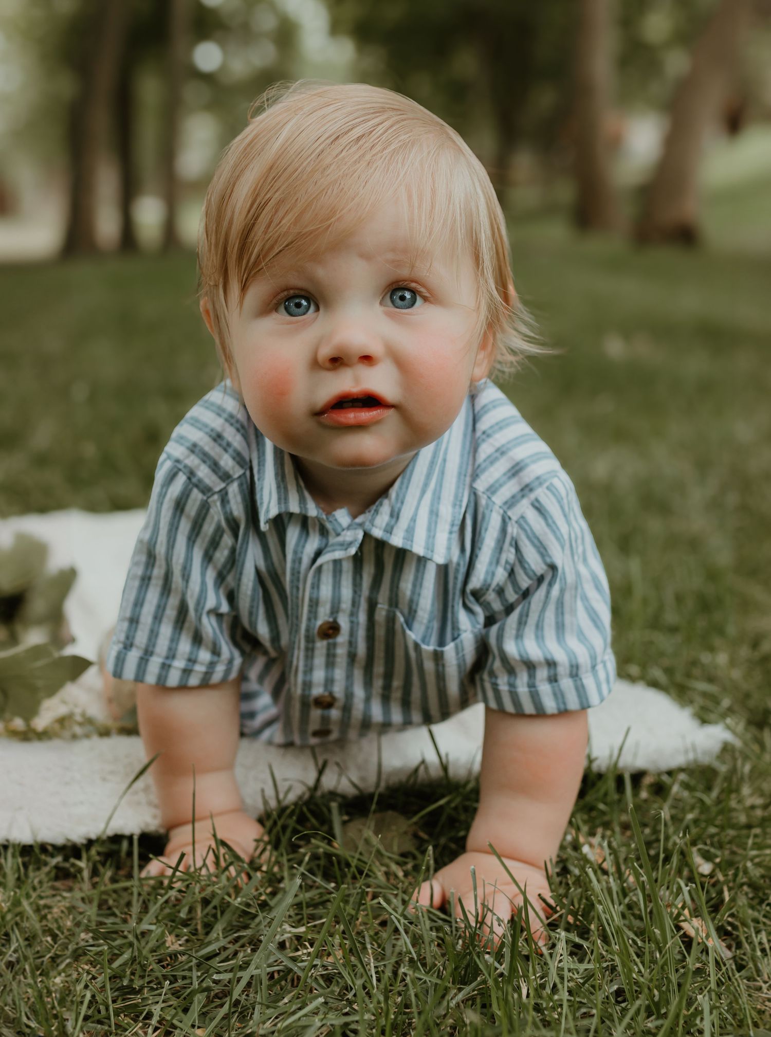 A close-up outdoor portrait featuring bright blue eyes and a striped button-up shirt. Colorado Springs Photographer.