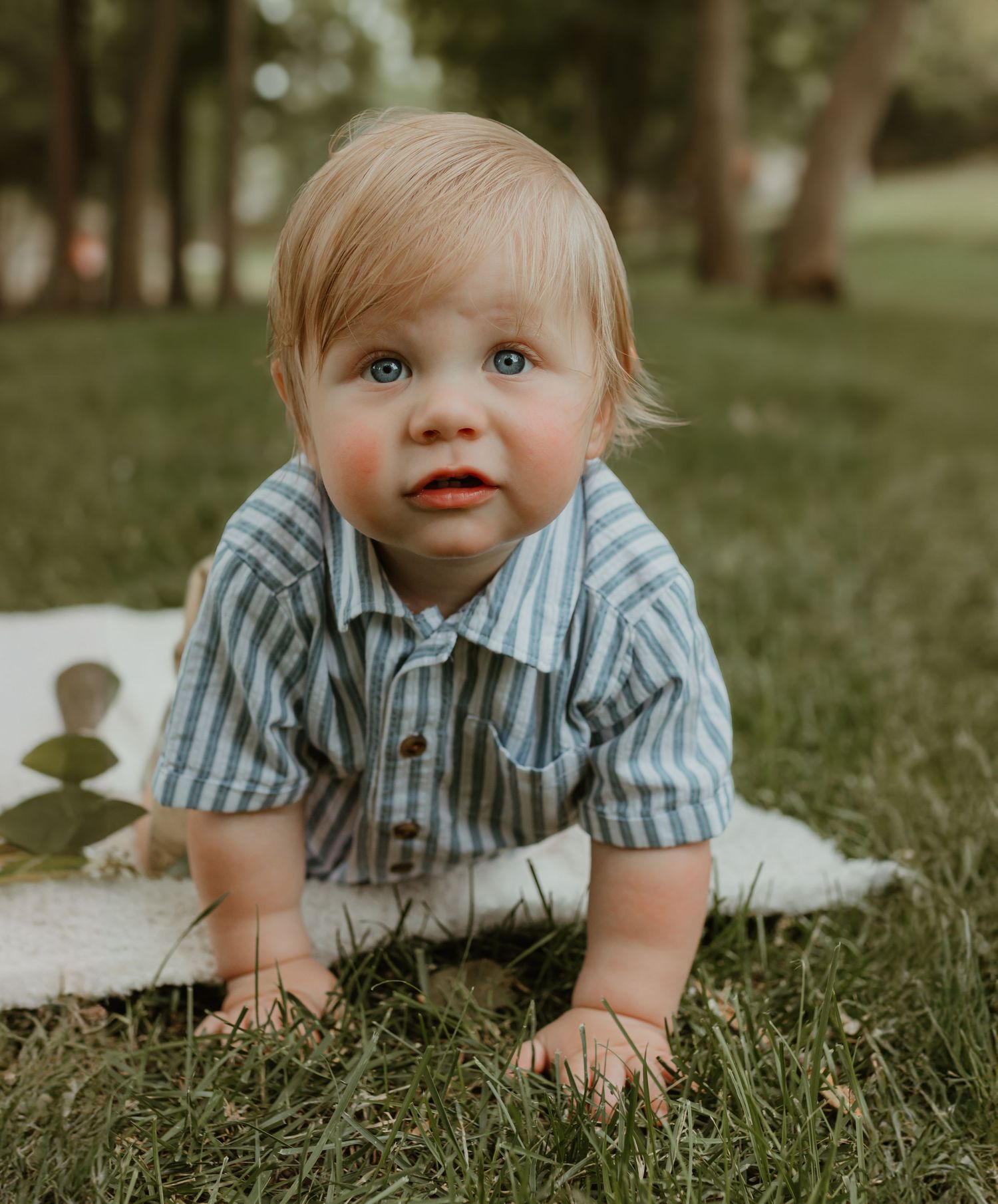 A sweet candid moment captured on a white blanket in a park setting. Colorado Springs Photographer.