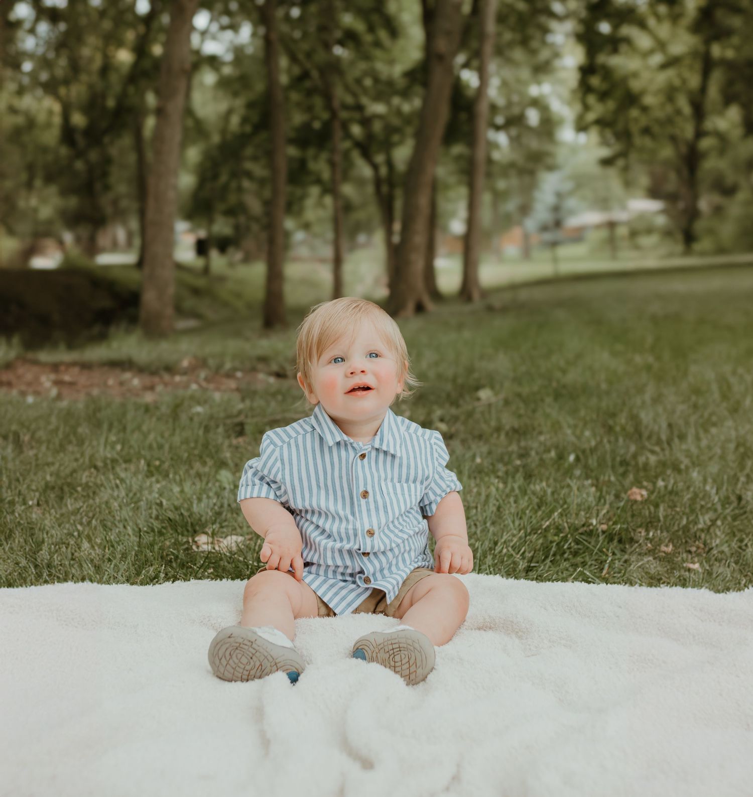 A charming outdoor portrait session on a white blanket surrounded by trees. Colorado Springs Photographer.