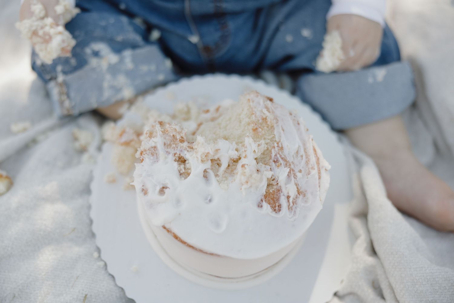 Hands mixing ingredients in a large bowl to make a white dough or batter for baking.