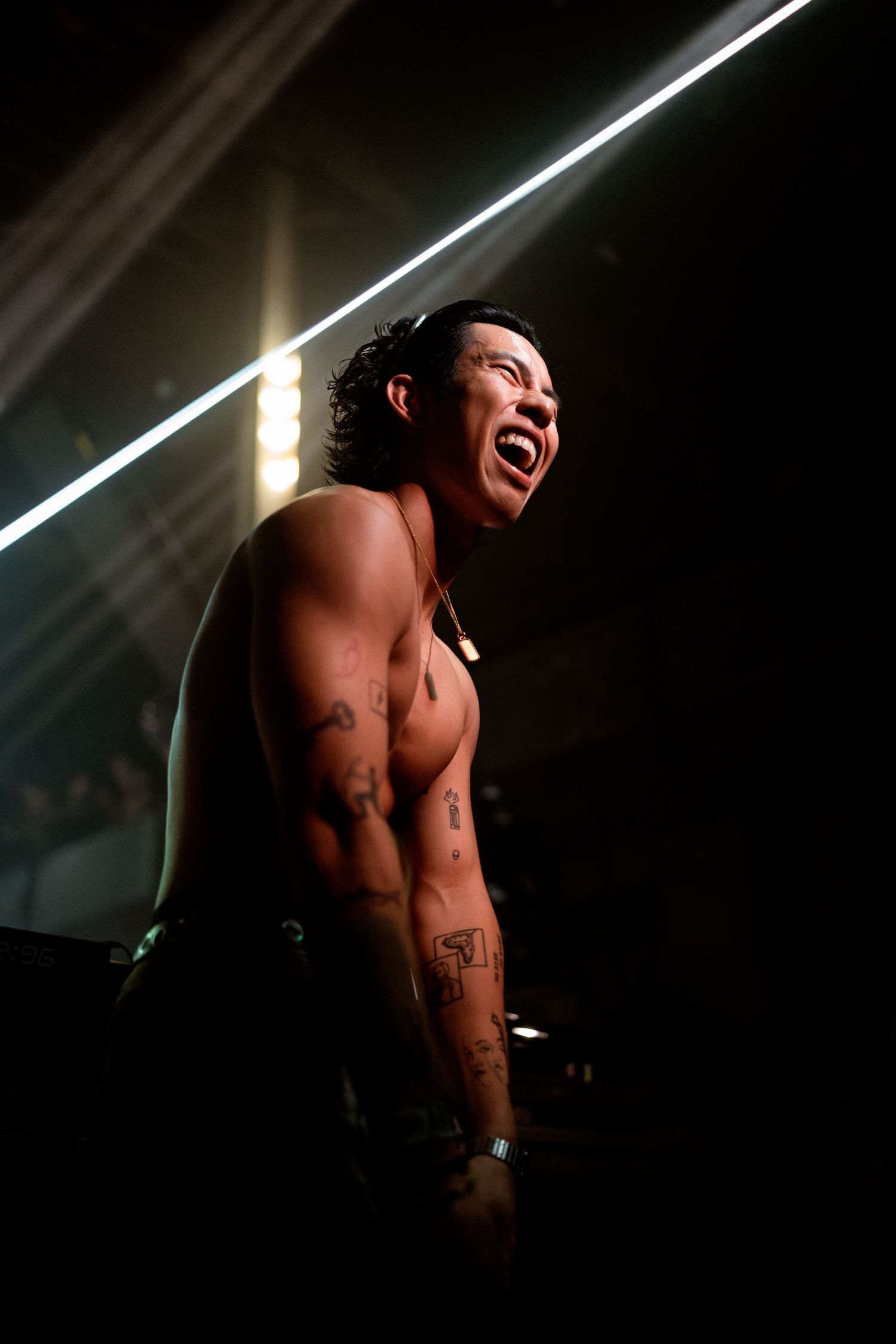 Dramatic stage lighting illuminates performer in emotional moment during show.