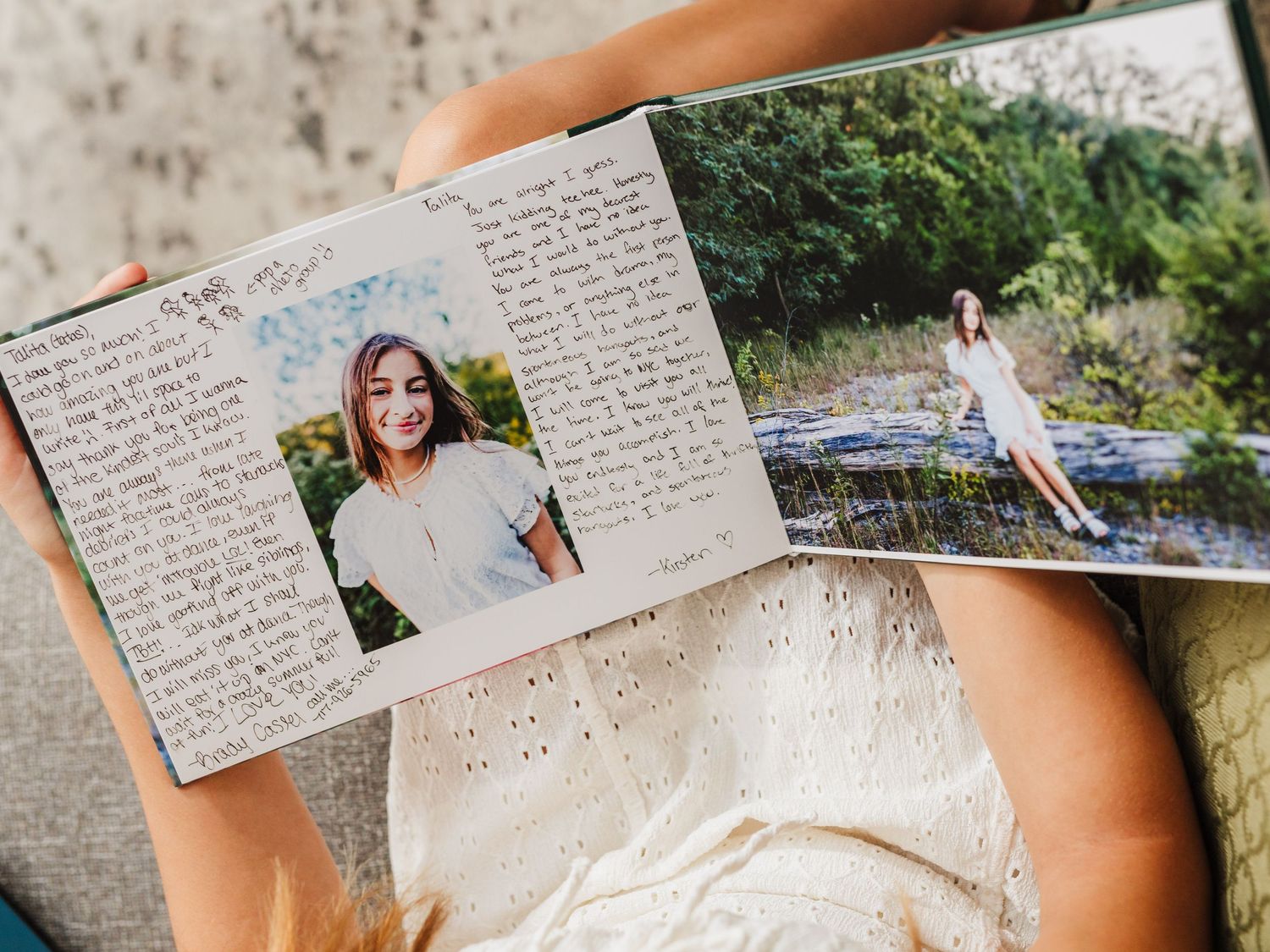 An open journal with handwritten text and personal photographs attached to the pages.