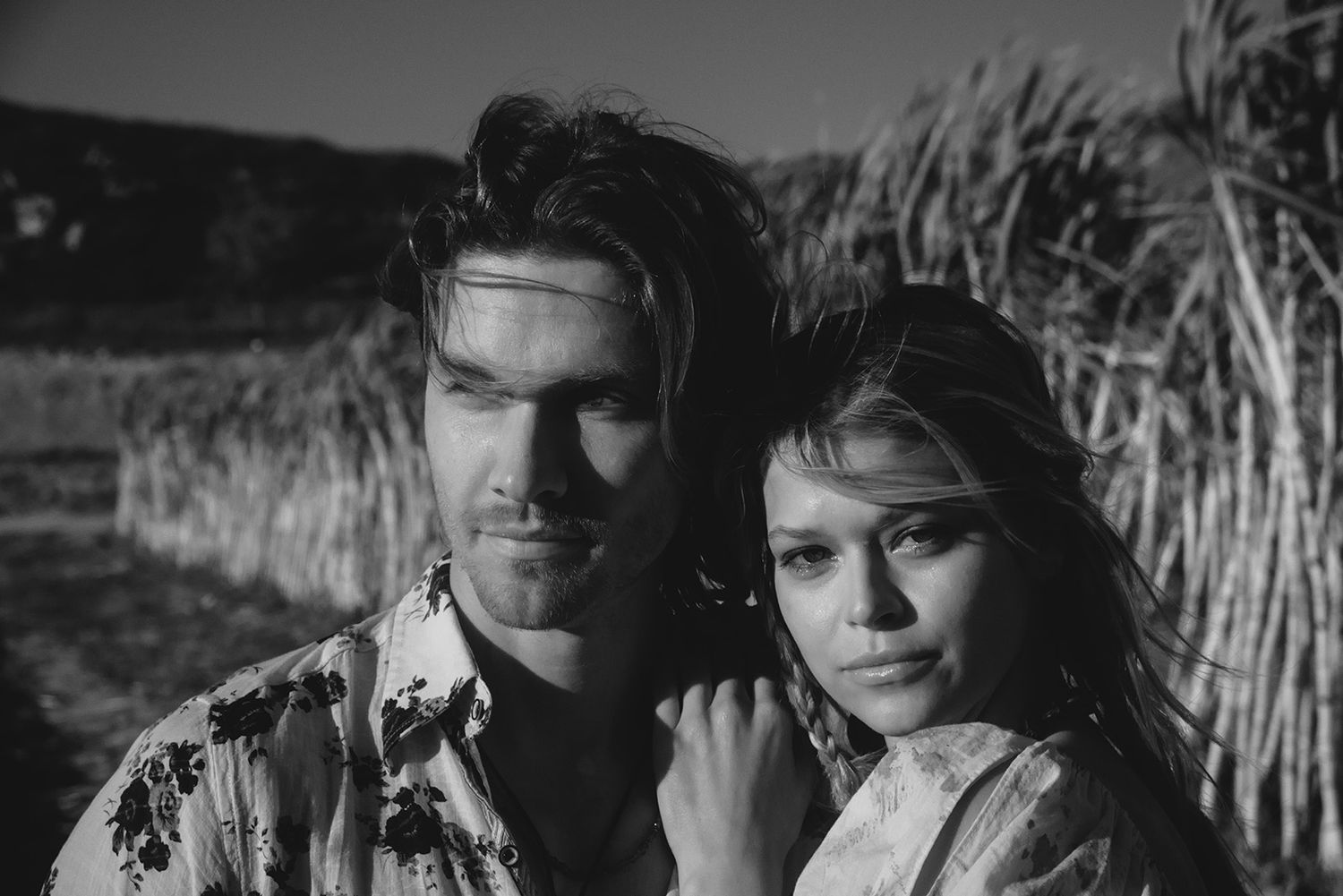 Black and white vintage-style portrait in a rustic setting.