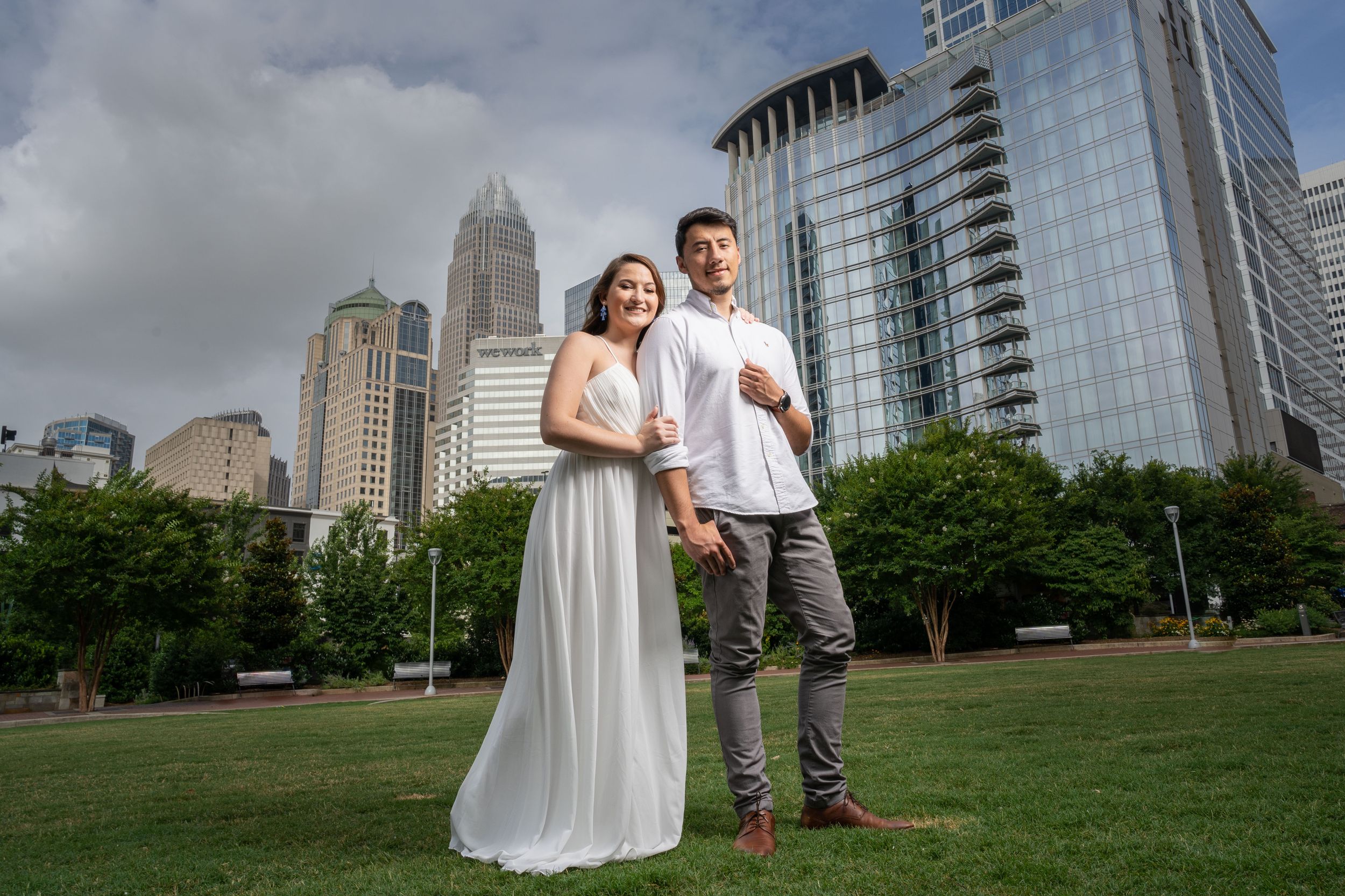 An urban engagement photo with Charlotte's skyline in the background.