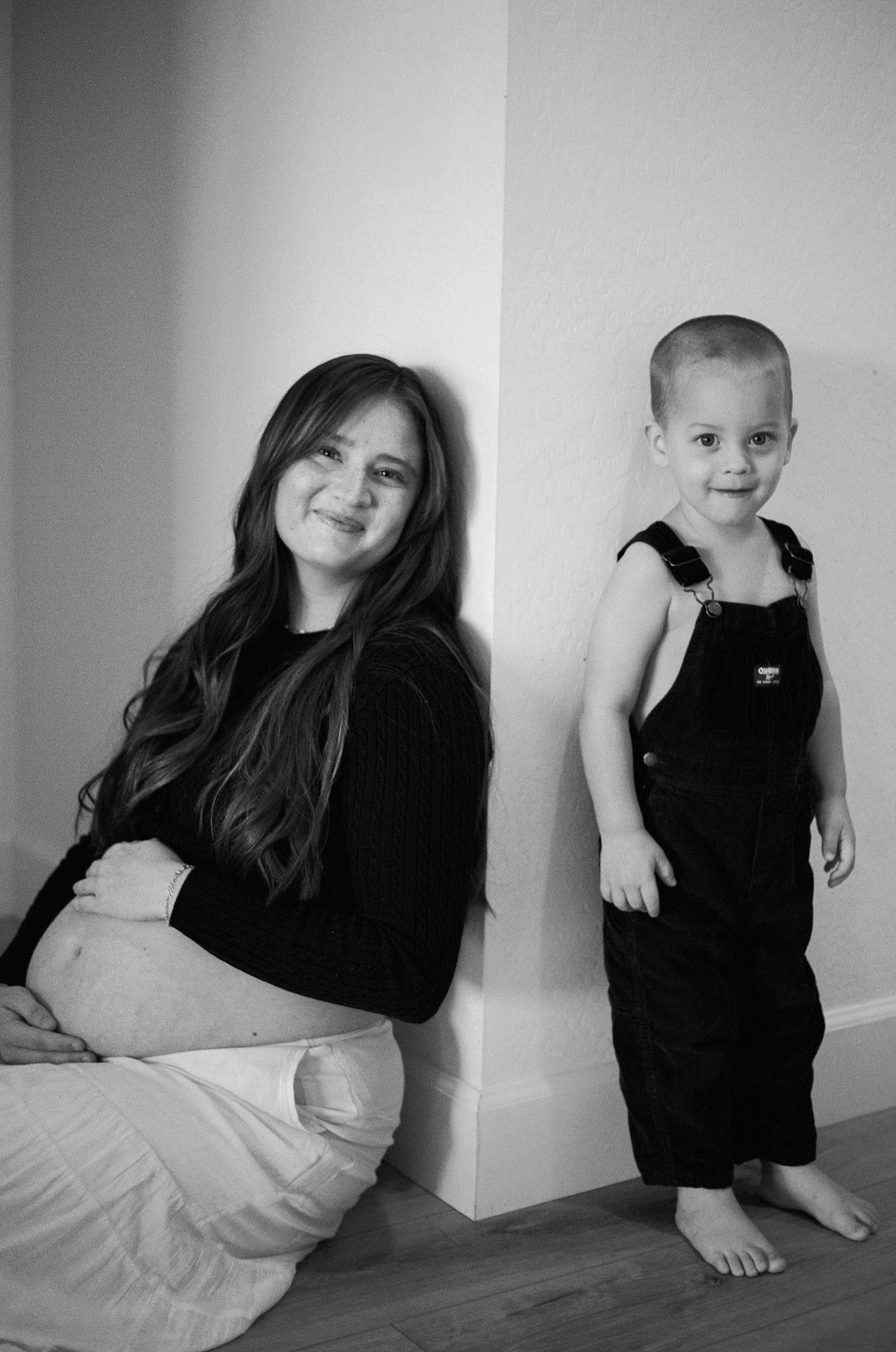 Series of black and white portraits showing figures in dark outfits against minimalist white wall.