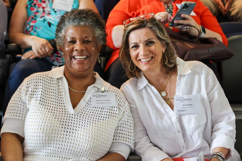 Two people sitting together and smiling during a community event.