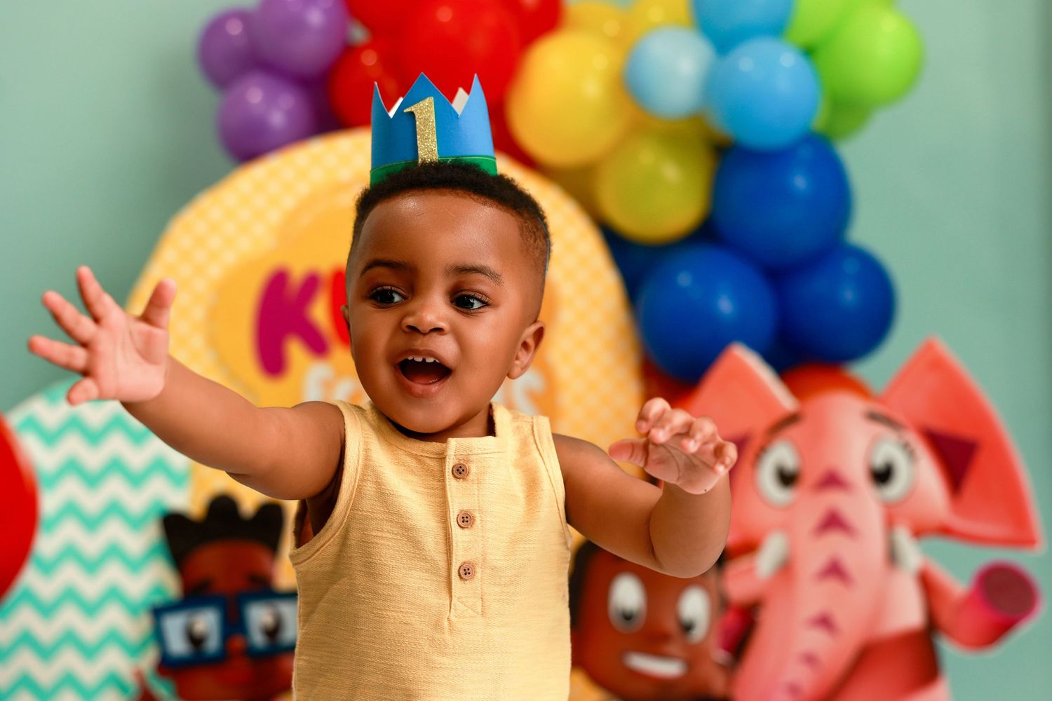 A colorful birthday party setup with balloons and decorations in bright shades of purple, red, green and blue.