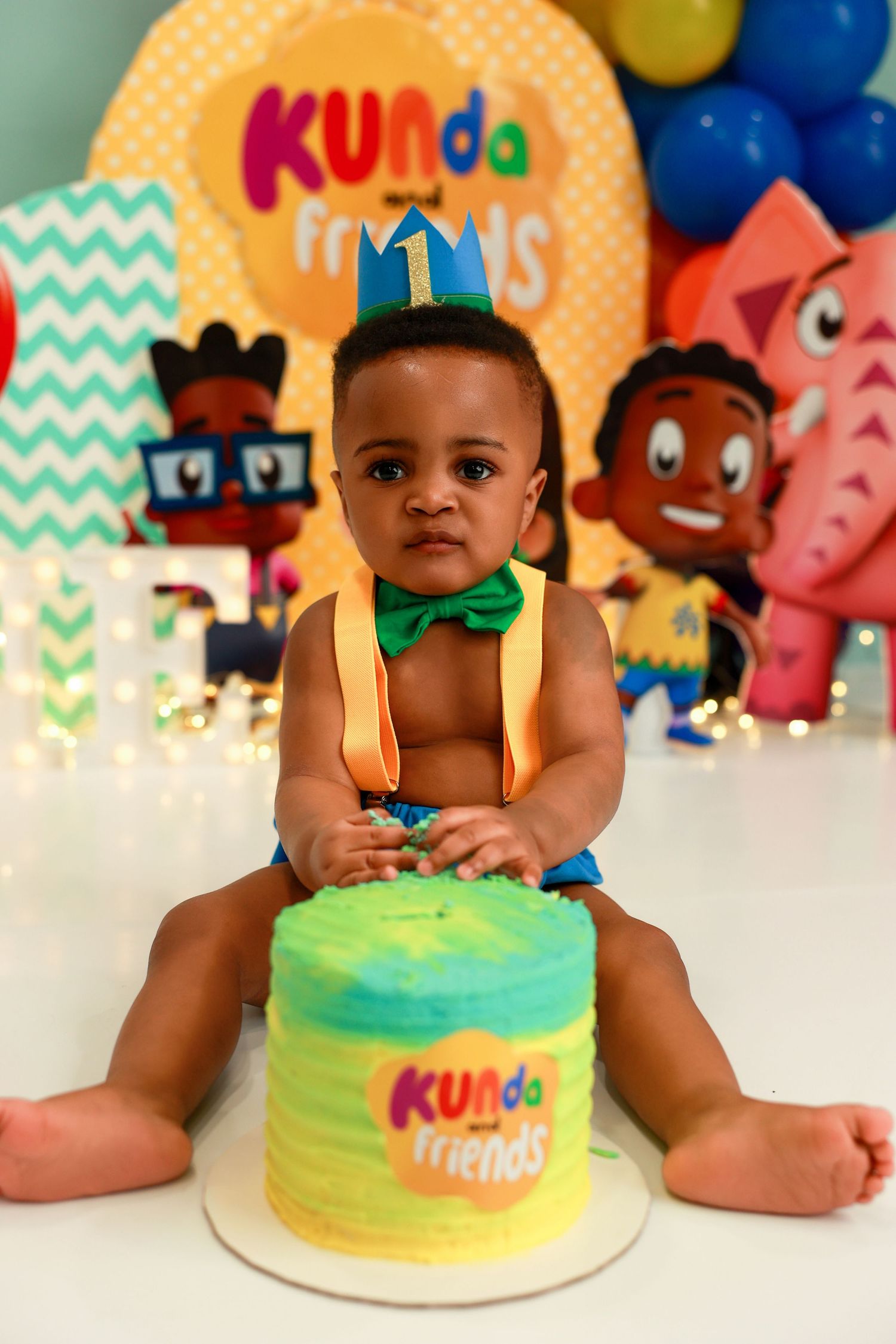 Birthday celebration scene with turquoise and yellow cake, colorful balloons, and party decorations.
