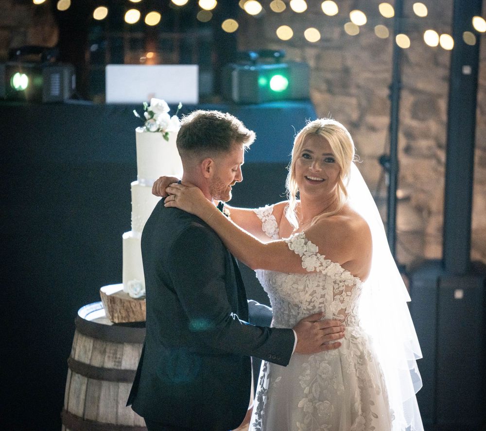 Romantic first dance between newlyweds with soft lighting and bokeh effects.