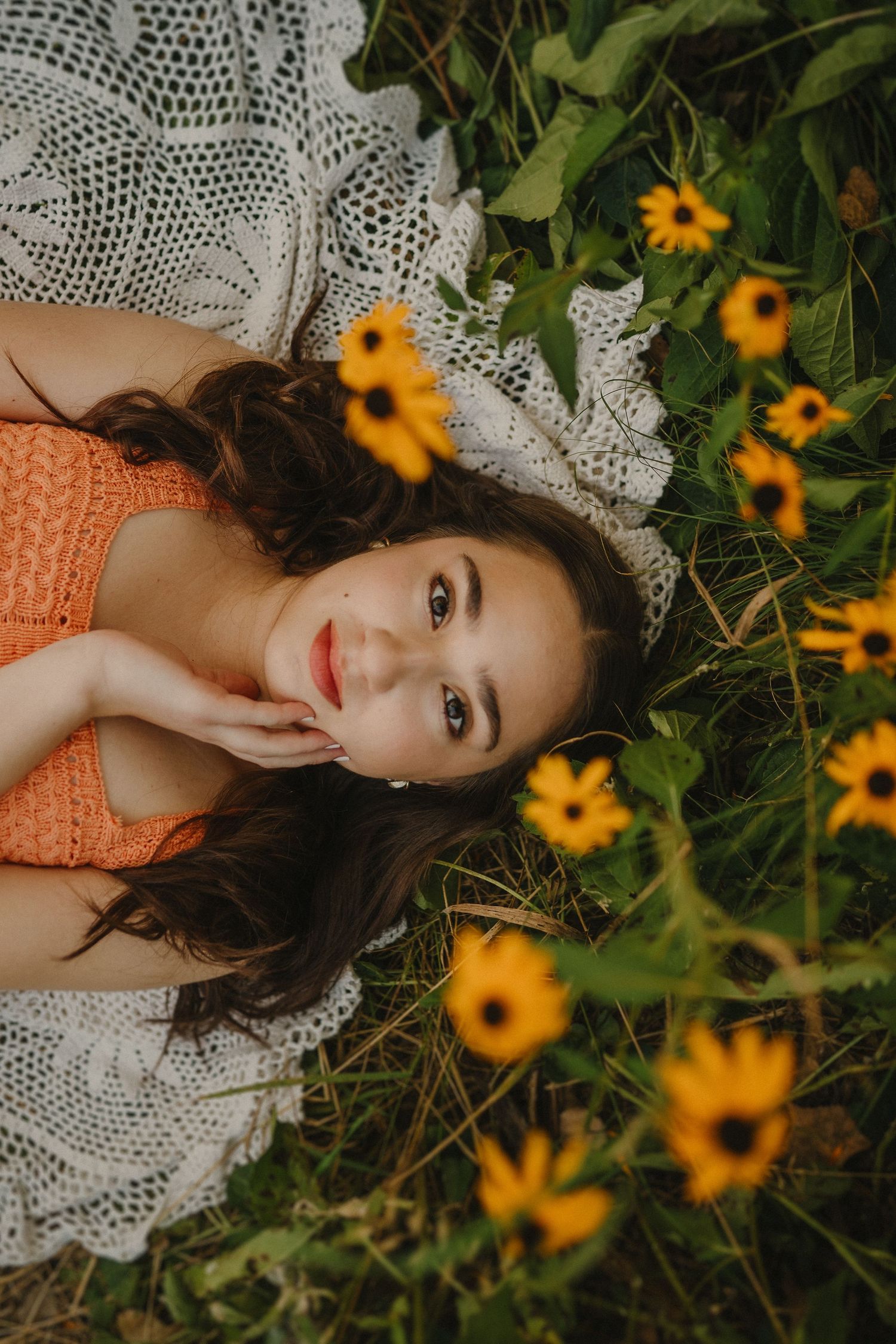 A dreamy portrait with yellow wildflowers and lace fabric creating a romantic summer scene in nature.