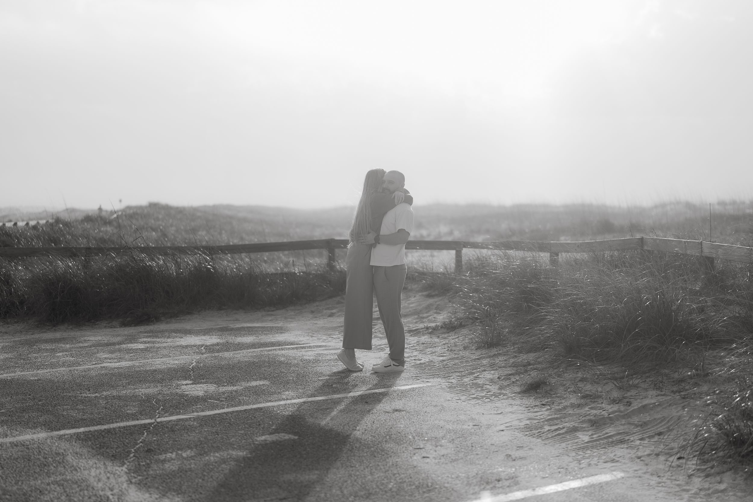 A silhouetted figure stands on a misty dirt path in a dreamy black and white landscape.