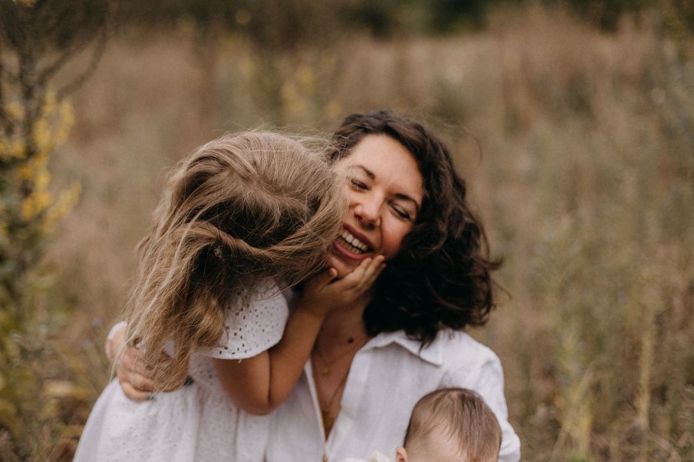 Sweet candid moment between parent and child showing pure joy and laughter outdoors.