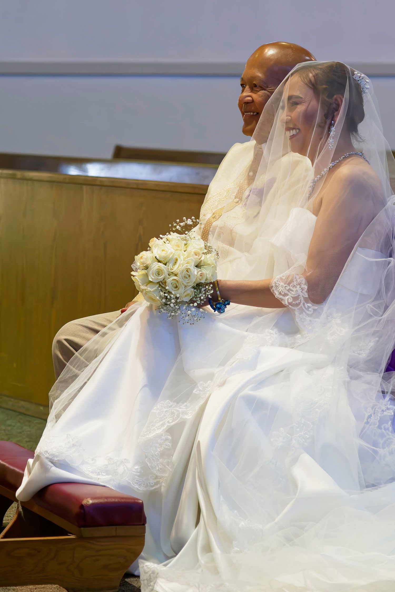Church pews decorated with purple and white satin fabric draping and bows for a special ceremony.