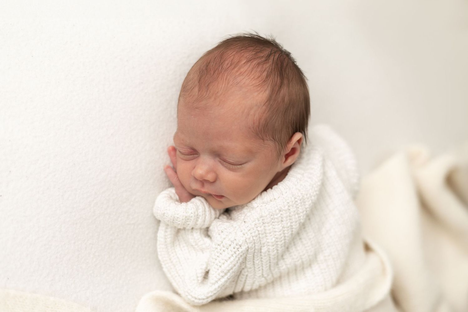 Natural baby photography Nottingham sleepy newborn wrapped in cream tones
