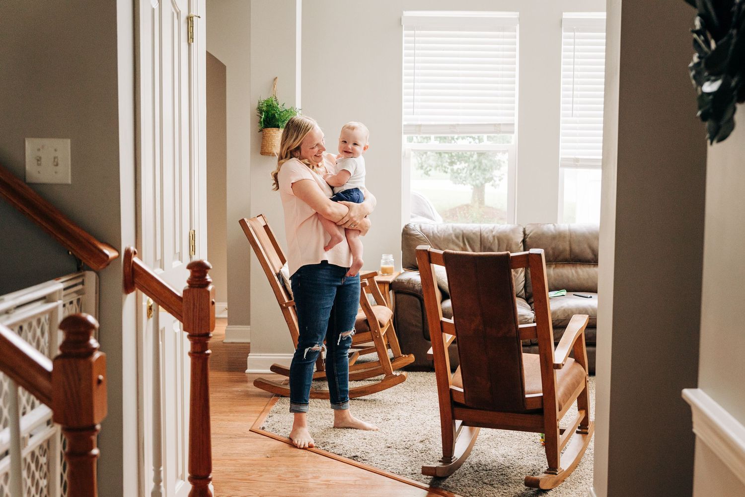 A mother holding her 8 month old during documentary photos in her living room in Charlotte, NC