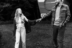Two people dance and laugh together in a backyard garden setting.