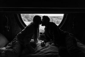 Silhouettes of people sitting in a car interior against a dark background.