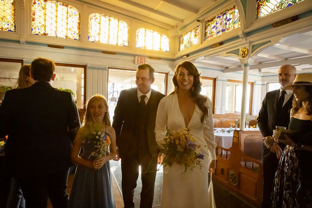 Wedding guests mingle and socialize in an elegantly lit indoor reception venue with warm ambient lighting.