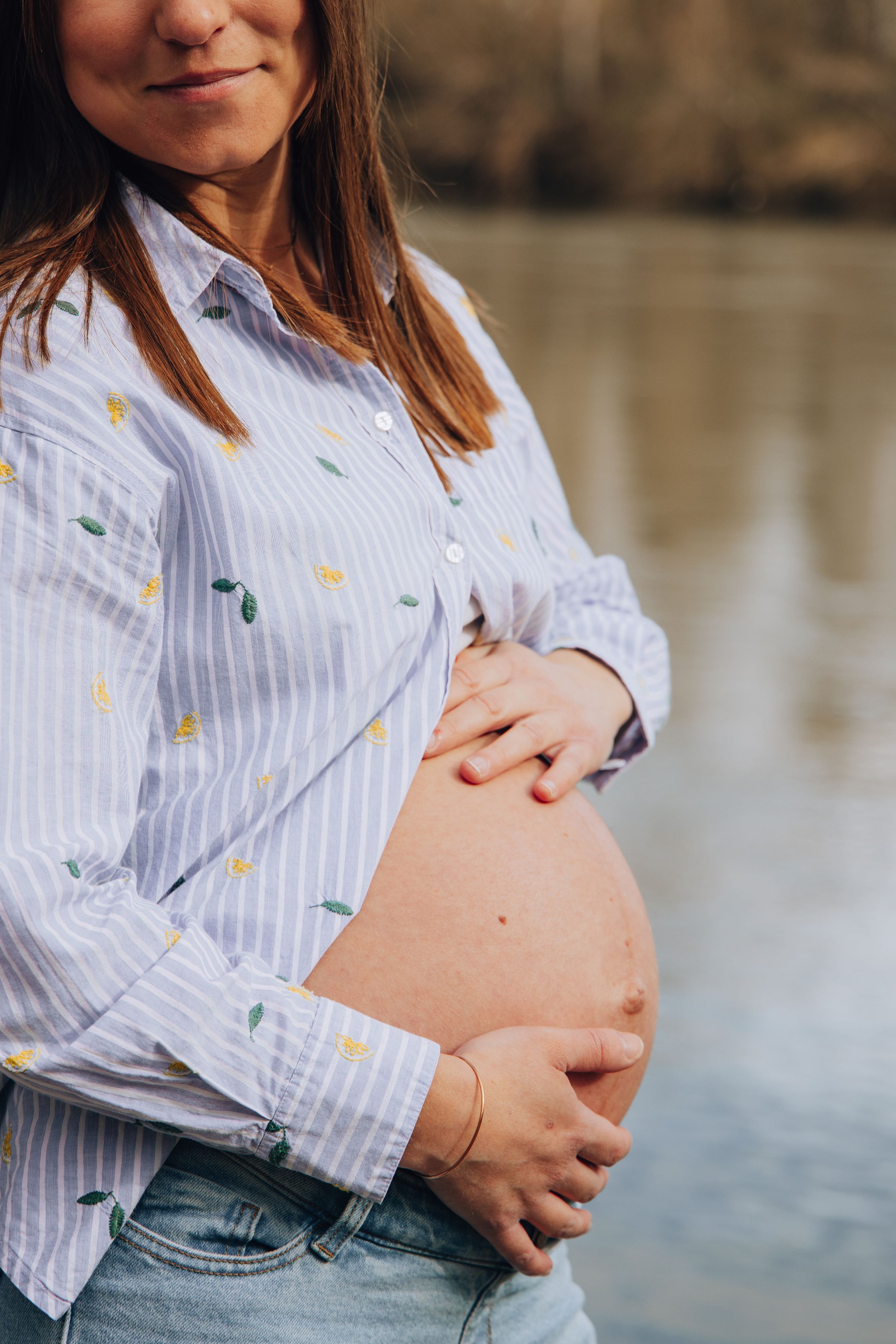 Focus sur les ventres de grossesse, entourés de mains posées avec tendresse lors d’une séance entre amies