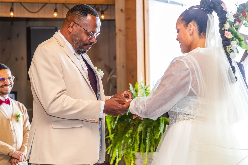Wedding party members in white attire celebrate during an indoor ceremony.