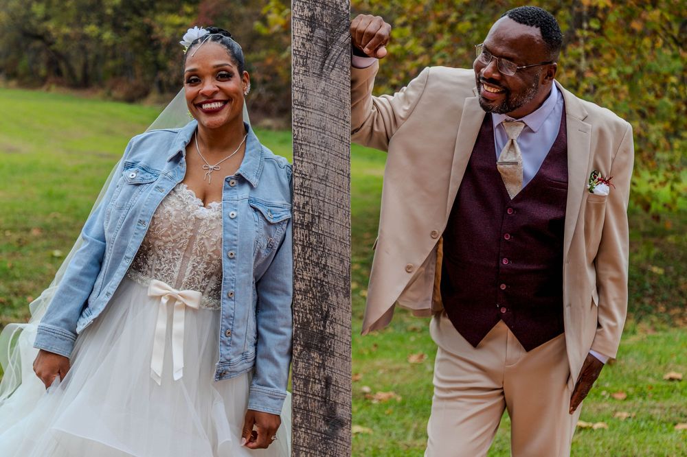 Couple enjoying a joyful moment together in an autumn outdoor setting with trees in the background.