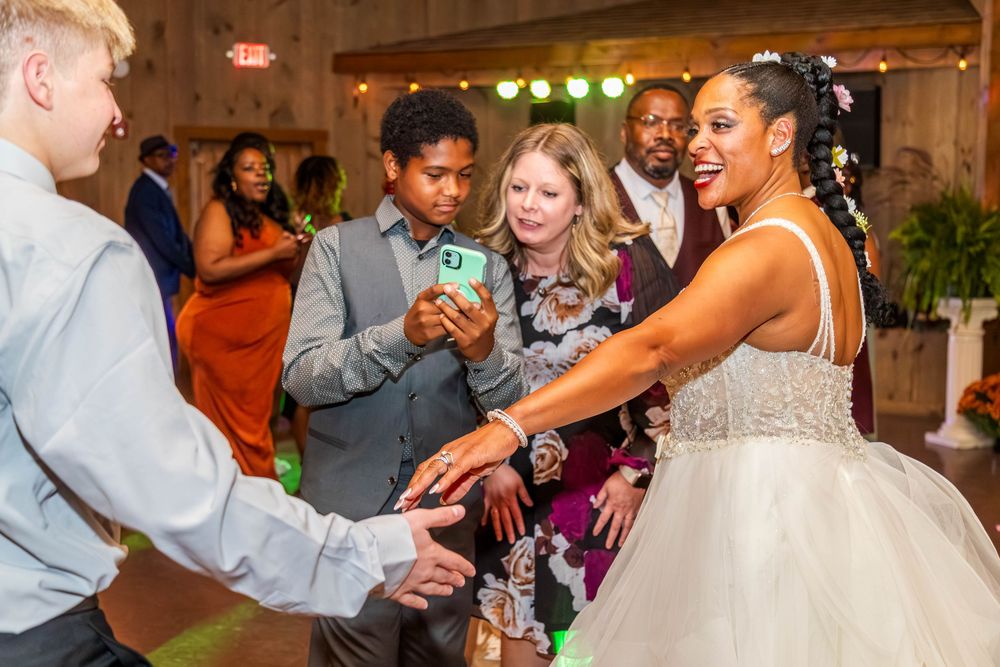 Wedding reception dance floor filled with joyful guests celebrating and dancing together.